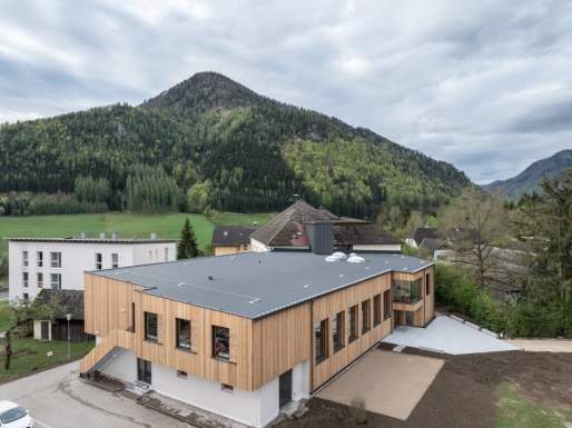 Luftaufnahme eines modernen Schulgebäudes mit Holzfassade